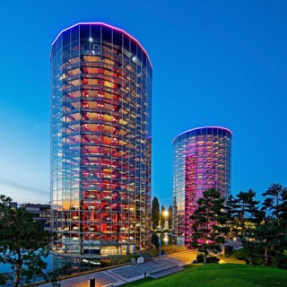 The illuminated car towers with new cars for delivery in the evening, Autostadt, Volkswagen AG,