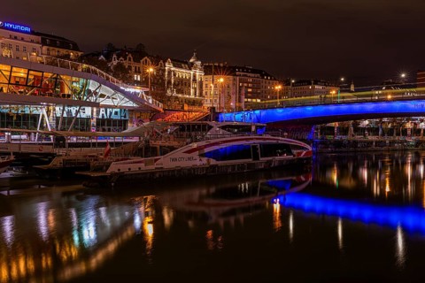 Ferry anchored in the Danube Canal, behind the illuminated Franz-Josefs Quay and St Mary's Bridge,