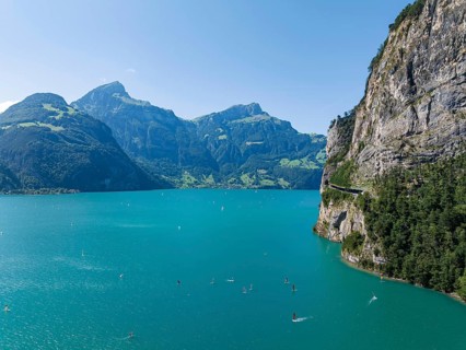 Lake Uri, part of Lake Lucerne near Flüelen, windsurfers in front of the mountains of the Alps.