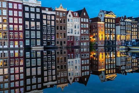 Canal houses on the Damrak, in the centre of the old town of Amsterdam, harbour, starting point of