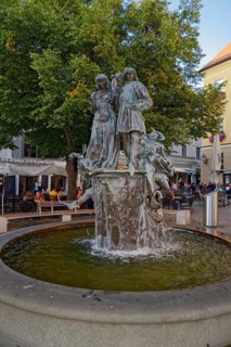 Wedding fountain with people and cafés in the background, market square, Amberg, Upper Palatinate,