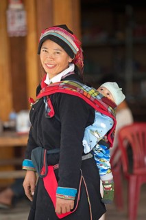 Vietnamese woman, 43 years old, in traditional traditional costume of the Dao minority, carrying