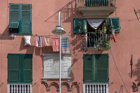 Residential building façade with green shutters and hanging laundry in the historic city centre,
