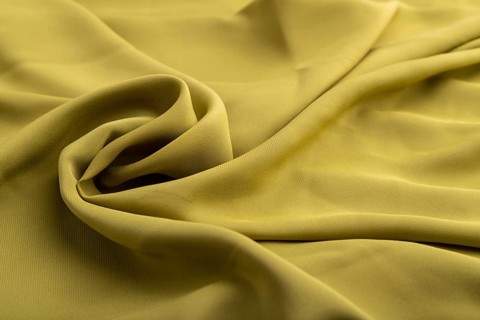 Fragment of green olive silk tissue. Side view, natural textile background and texture. wave