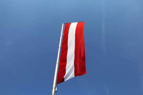 Österreichische Flagge vor blauem Himmel (Austrian flag in front of a blue sky)