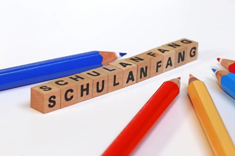 Symbolic image for the start of the new school year with letter cubes and pens