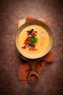 Pumpkin cream soup, curry, fried bacon, top view, no people