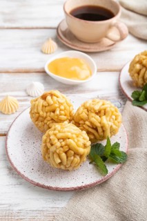 Traditional Tatar candy chak-chak made of dough and honey with cup of coffee on a white wooden