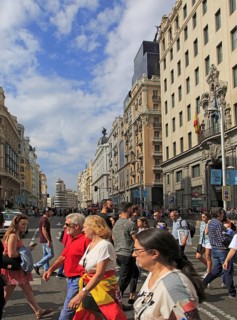 Pedestrians crossing busy road of Gran Via, Madrid city centre, Spain, Europe