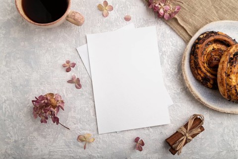 White paper invitation card, mockup with hydrangea flowers, bun, cup of coffee, linen textile,