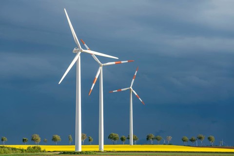 Wind turbines on a rape field, dark rain clouds, in the Rhenish lignite mining area, near