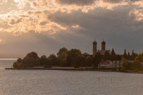 Baroque castle church, double tower, onion dome, evening light, sunbeams, Friedrichshafen on Lake