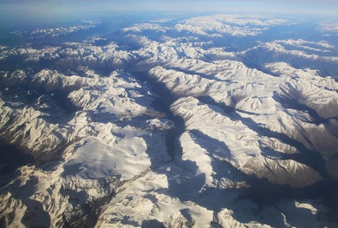 View from plane of snow covered mountain peaks in the Alps between France and Italy