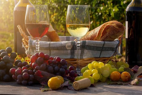 Symbolic image: Ripe grapes decorated with wine glasses on a wooden table