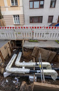 Construction site of a district heating house connection, pipes, insulated, are laid from a central