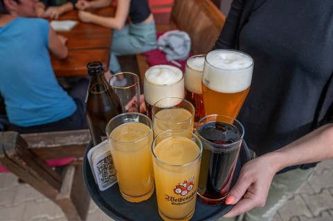 Waitress brings drinks to a table in a beer garden, Bavaria, Germany, Europe
