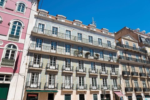 Building facades of an old town with multi-storey buildings and balconies under a clear sky, house
