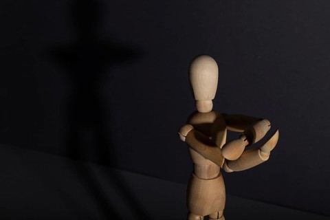 Wooden mannequin shows obscene gesture fuck off with hands on gray background. protest, riot,