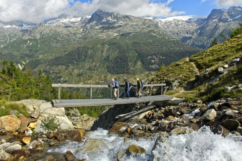 Hikers cross a narrow bridge over the Nästbach torrent on the way to the Bietschhorn hut, near