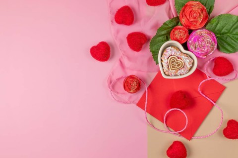 Romantic composition with roses, hearts and an envelope, heart-shaped cupcake, ideal for