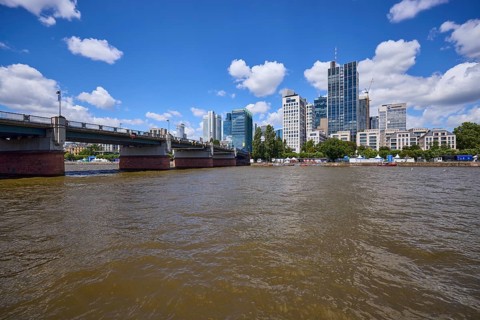 Untermainbrücke, Main river and skyscrapers under blue sky with cumulus clouds in Frankfurt am