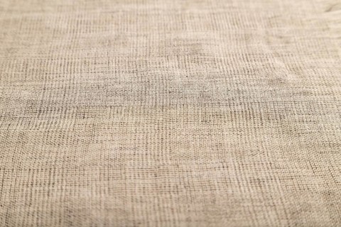 Fragment of smooth brown linen tissue. Side view, natural textile background and texture