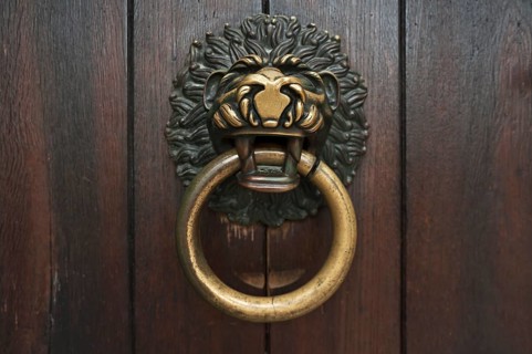 Lion's head as a door knocker on the Romanesque entrance portal of the Schottenkirche Sankt Jakob,