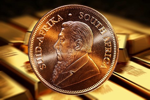 Close-up of a Krugerrand gold coin, in the background blurred gold bars (composing)