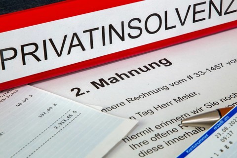 Symbolic image of personal insolvency: folder, bank statement and a reminder