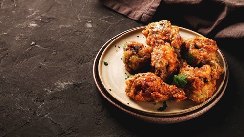 Fried chicken legs, breaded, with spices and herbs, on a dark background, horizontal, no people,