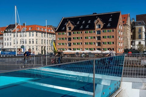 Cyclists on the Inderhavnsbroen cycle and footpath bridge, over the harbour, at Nyhavn, Copenhagen