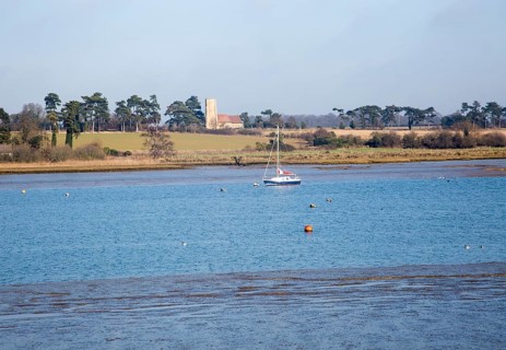 Ramsholt church and moored yacht seen from across River Deben, near Kirton Creek, Suffolk, England,