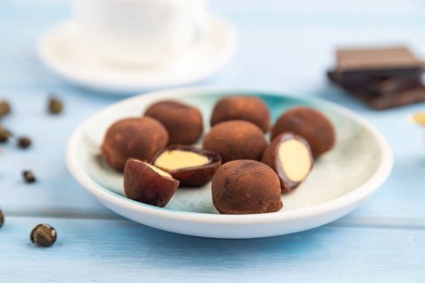Japanese rice sweet buns chocolate mochi filled with cream and cup of green tea on blue wooden