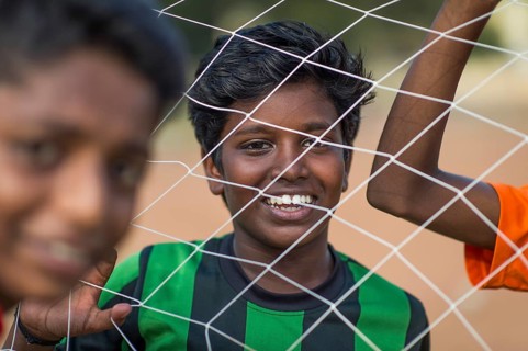 Laughing boys looking through goal net, football, Parade Ground, Fort Cochin, Kochi, Kerala, South