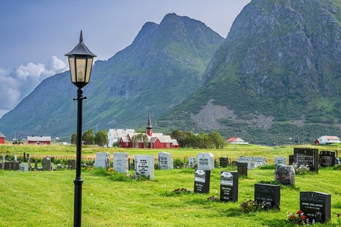 Graveyard of Flakstad, Flakstad church in the back, red wooden building, Flakstad, Lofoten, Norway,