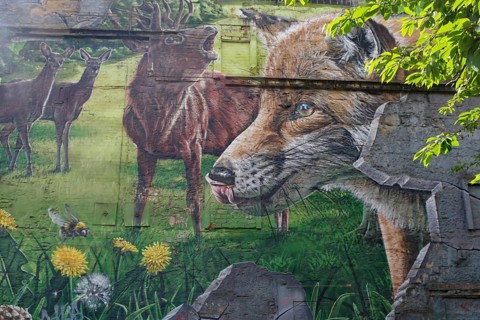 Vibrant mural depicting a fox, deer and a green meadow with flowers and trees, Mural Trail,