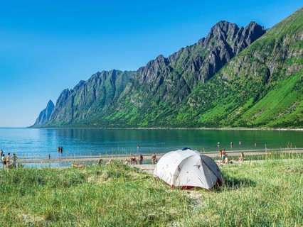 Beach Ersfjordstranden, fjord Ersfjord, public recreation area, tent on the beach, people enjoy the