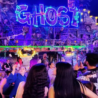 People in front of the illuminated ghost train Ghost in the evening, Cranger Kirmes, Herne, Ruhr