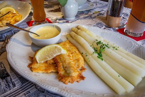 Limandes fillet fried with asparagus and hollandaise sauce in the fish restaurant Wremer