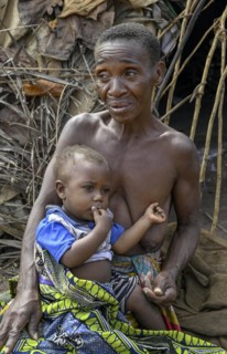 Pygmy woman of the Baka or BaAka people with her child in front of her hut, Bayanga, Sangha-Mbaéré