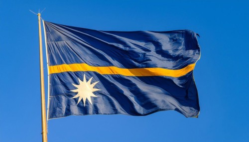 The flag of Nauru, an island nation in the Pacific Ocean, flutters in the wind, isolated against a