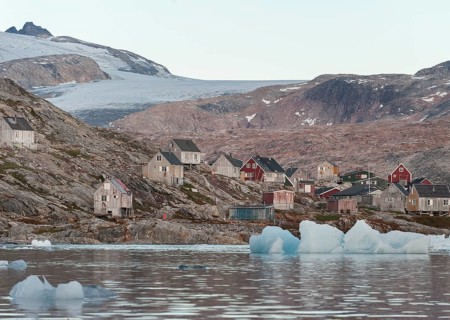 Icebergs in front of wooden houses in the Inuit settlement of Tiniteqilaaq, Sermilik Fjord, East