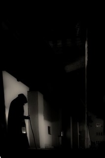 Old man with hood, stick and lantern in gloomy city neighbourhood, Mindelheim, Unterallgäu,