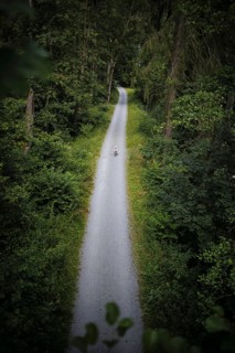 A child on a balance bike rides along a hiking trail through the Höllental valley between Thuringia