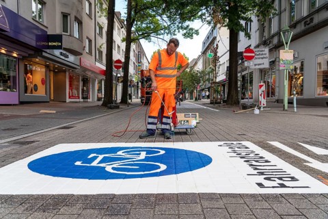 Application of road markings for a cycle lane, Rüttenscheider Straße in Essen, in the shopping and