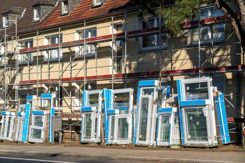 Energy-efficient refurbishment of residential buildings, older apartment block is scaffolded, gets
