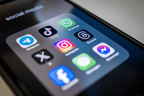 Close-up of a smartphone screen with various social media apps, diffuse light