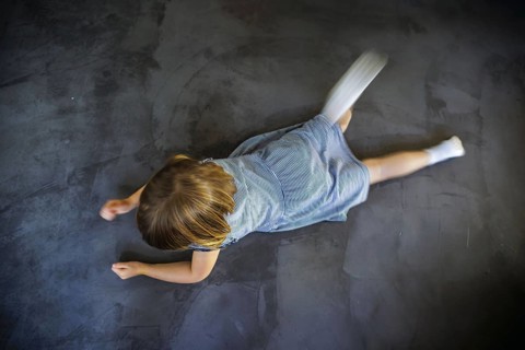 Symbol photo on the subject of tantrums (posed scene) . A little girl is lying on the floor,