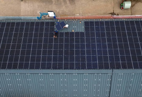Installation of solar modules on the roof of a barn on a farm, over 210 photovoltaic modules are