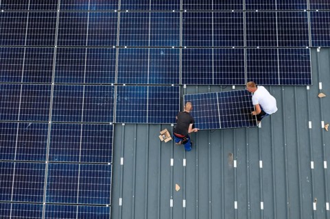 Installation of solar modules on the roof of a barn on a farm, over 210 photovoltaic modules are